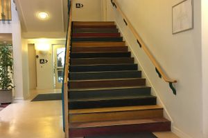 Gelænder på plads på begge sider af trappe i Skanderborg Sundhedshus.